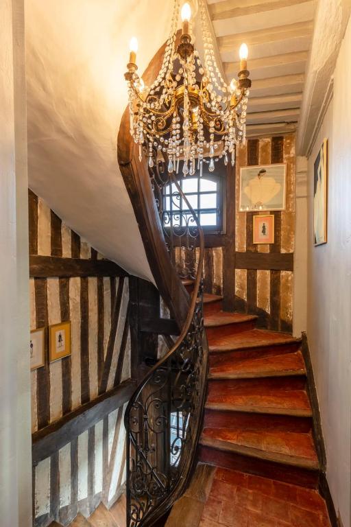 a chandelier hangs over a staircase in a house at La Demeure du Clocher 4 - On the Port and Place St Catherine - 8 P in Honfleur