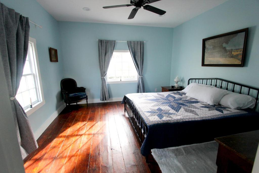 a bedroom with a bed and a ceiling fan at Cozy, historic 5-bedroom home in Amish country in Smicksburg