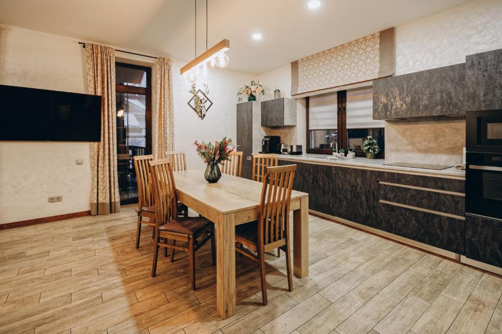 a kitchen and dining room with a wooden table and chairs at Finlandia Chalet in Bukovel