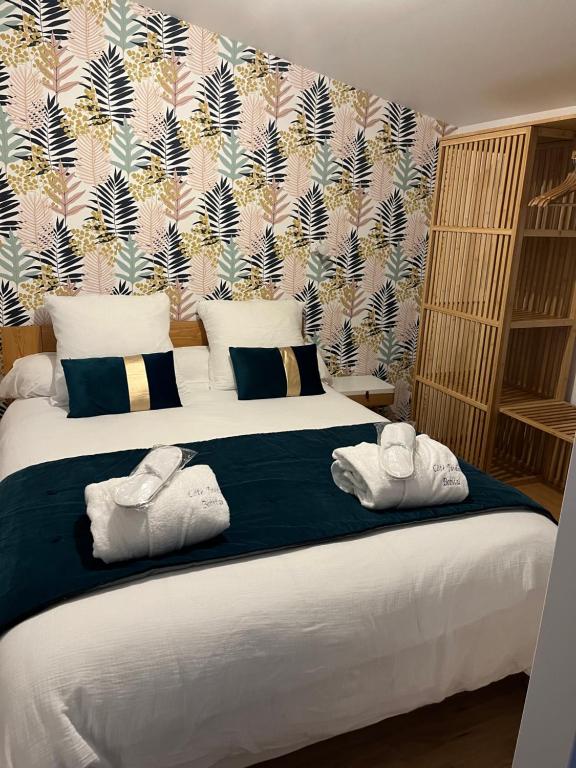 Bobital的住宿－Côté Jardin，一间卧室配有一张大床和毛巾