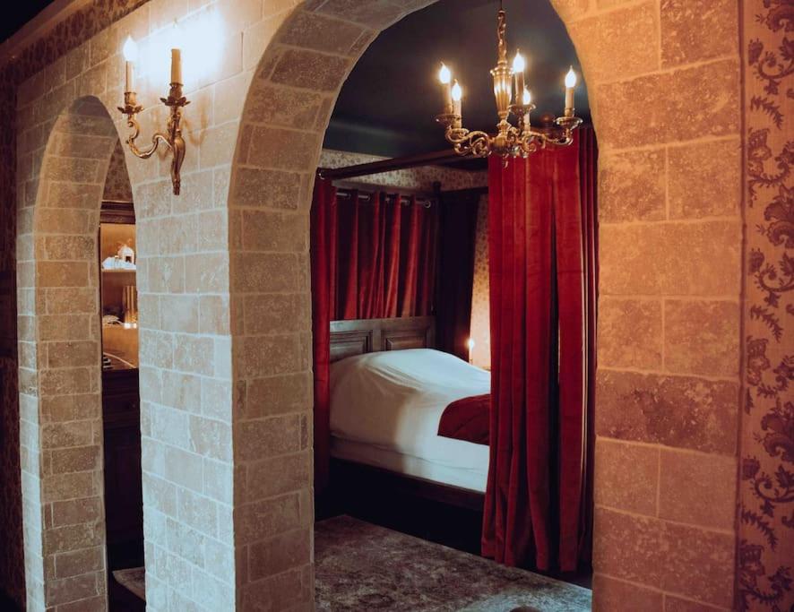 sypialnia z łóżkiem i czerwoną zasłoną w obiekcie LA SALLE DES SORTILÈGES w Perpignanie