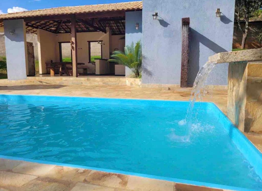 a swimming pool with a water fountain in front of a house at Casa Jatobá da Serra in Serra do Cipo