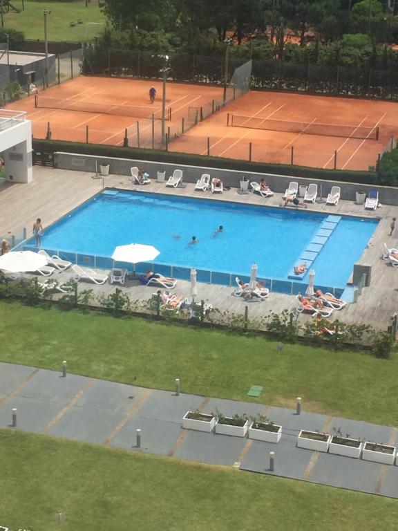 una vista aérea de una gran piscina con pista de tenis en Apartamento hermoso en Punta del Este, en Punta del Este