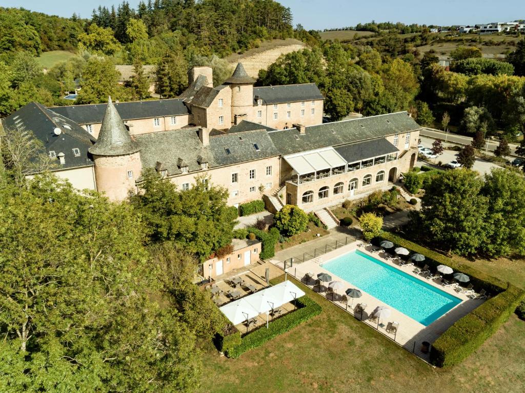 - une vue aérienne sur un grand domaine avec une piscine dans l'établissement Château de Fontanges, à Onet le Château
