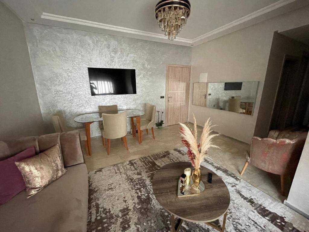 un soggiorno con divano e tavolo di Superbe Appartement Bouskoura a Bouskoura