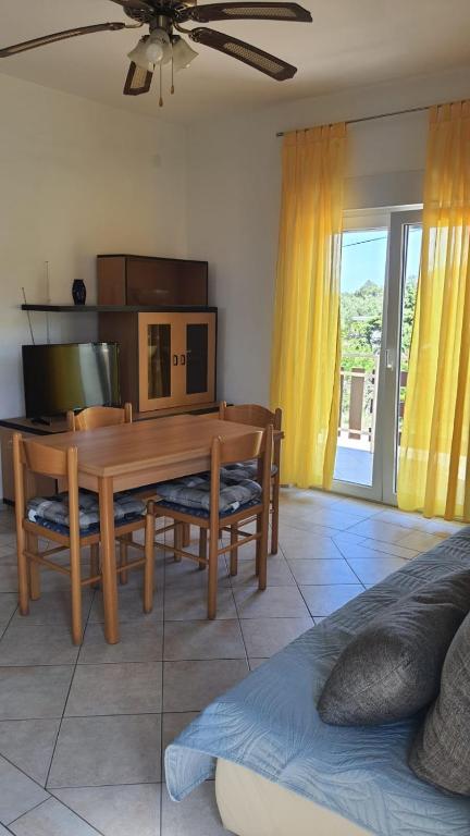 a dining room with a table and chairs and a couch at Apartments Irena in Božava