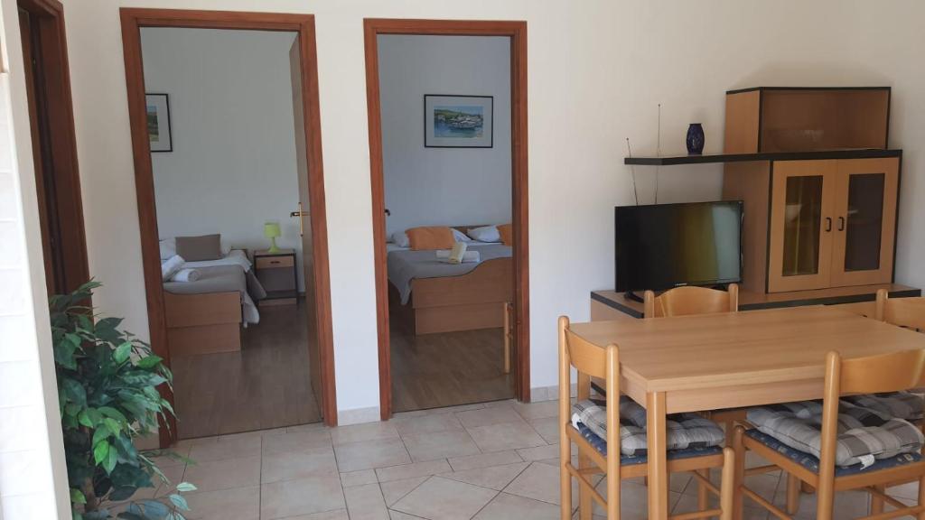 a living room with a dining room table and a television at Apartments Irena in Božava