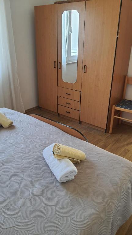 a bedroom with a bed with a towel and a mirror at Apartments Irena in Božava
