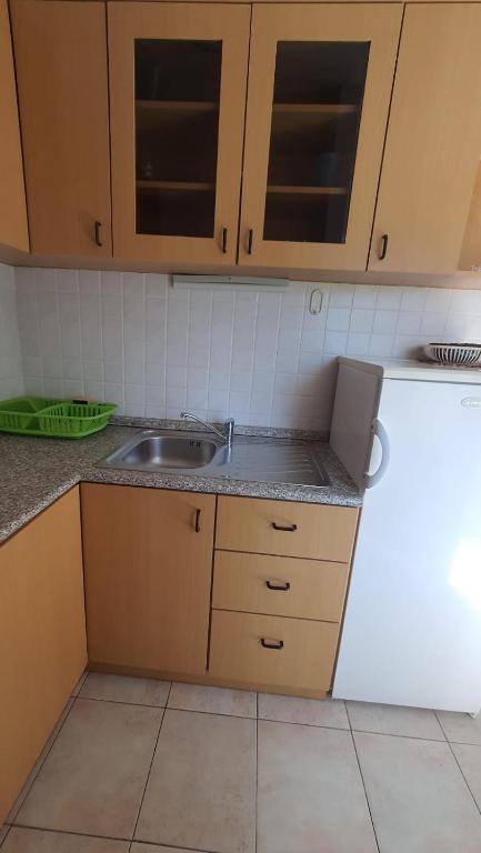 a kitchen with wooden cabinets and a sink at Apartments Irena in Božava