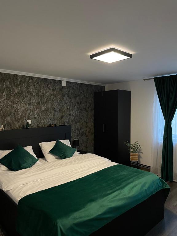 a bedroom with a large bed with green sheets at MontApart in Buşteni