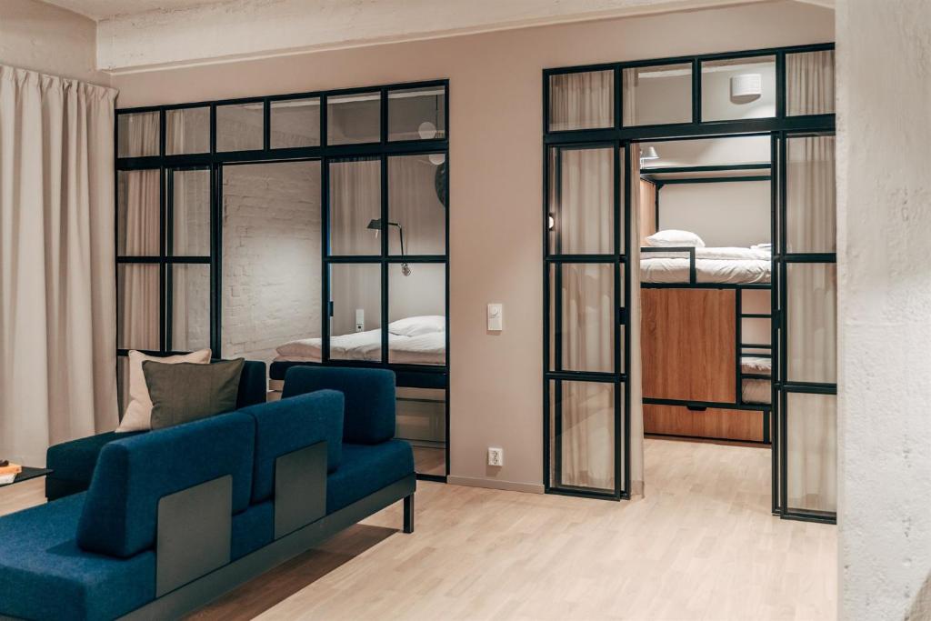 un soggiorno con divano blu e letti a castello di Unity Tampere - A Studio Hotel a Tampere
