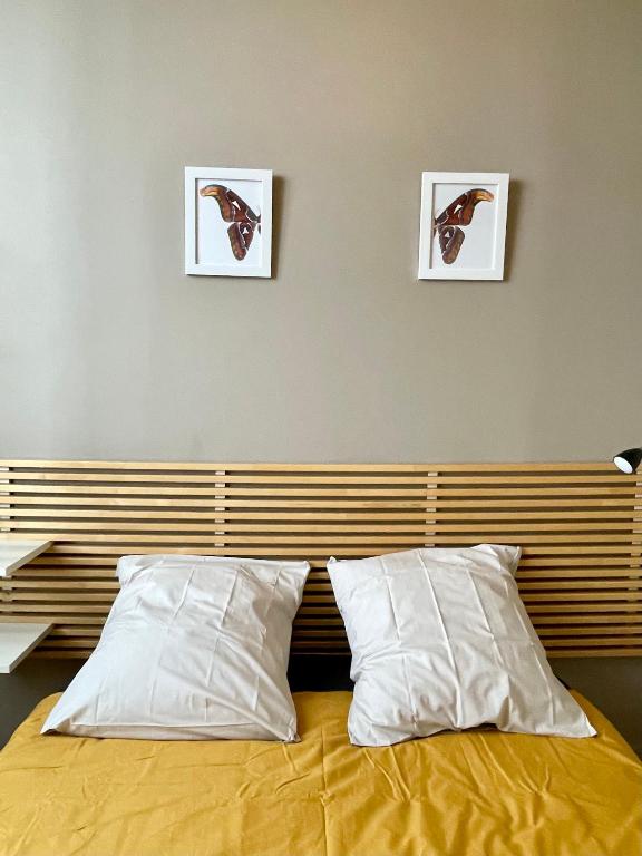 łóżko z 2 poduszkami i 3 zdjęciami na ścianie w obiekcie unique! Maison sur 1 toit avec vue extraordinaire! w mieście Lyon
