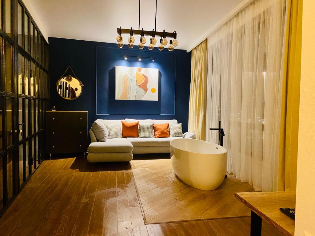 a living room with a bath tub and a couch at LUXURY APARTMENT IN OLD TBILISI WITH TERRACe in Tbilisi City