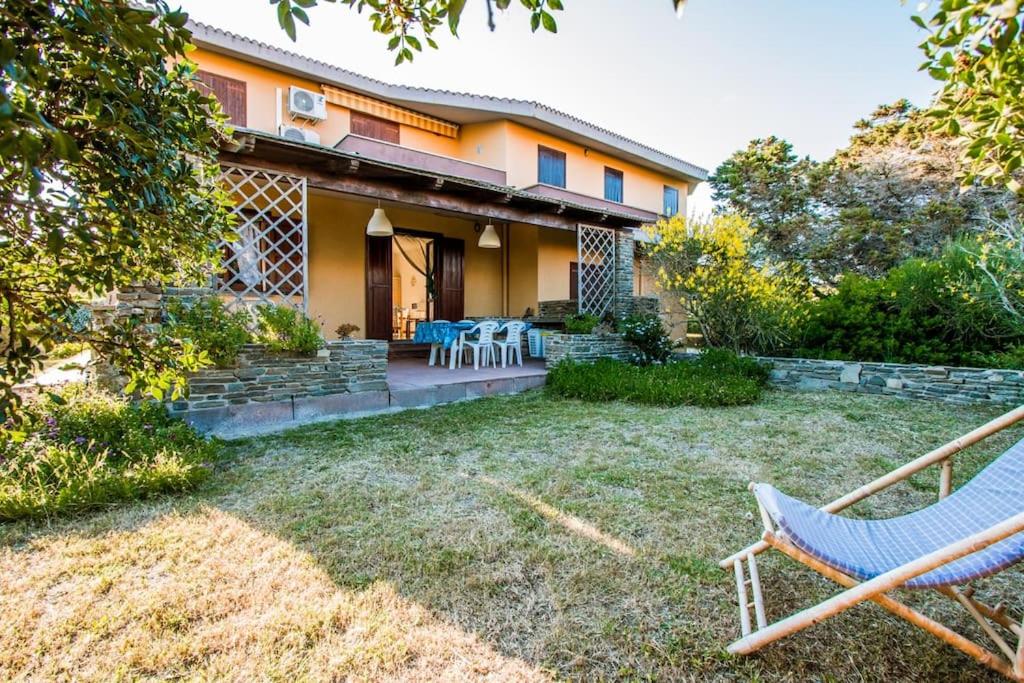 a house with a yard with two chairs in front of it at A pochi passi dal mare, con giardino privato - A few meters from the sea, with private garden in Stintino