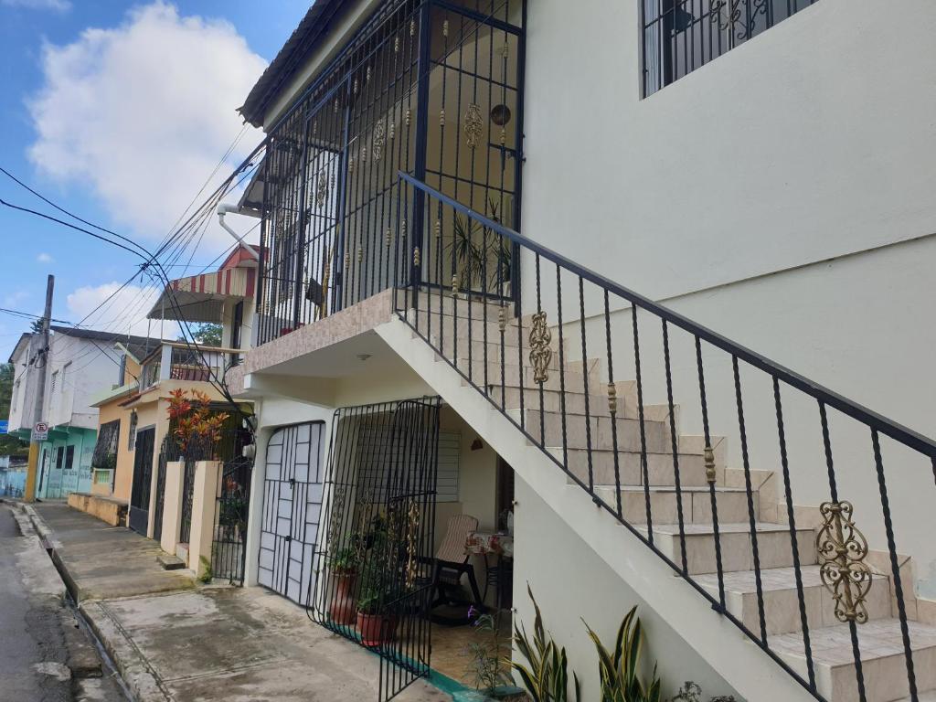 a white building with a staircase next to a street at Margarita in Río San Juan