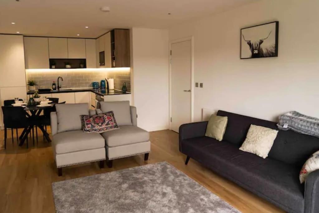 a living room with a couch and a chair and a table at Lavish 2 Bedroom Apartment in Colindale