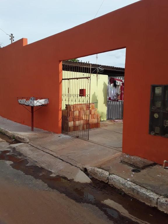 an orange building with a gate in front of a street at Home Comfort in Poconé
