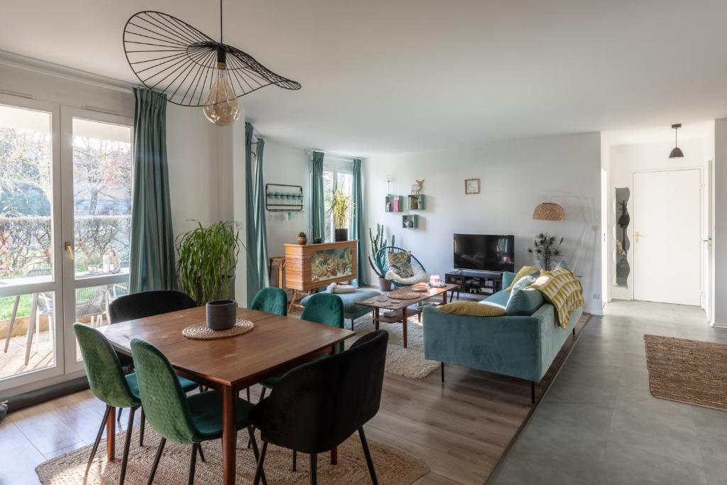 sala de estar con mesa, sillas y sofá en Appartement très calme, terrasse & jardin en ville en Besanzón