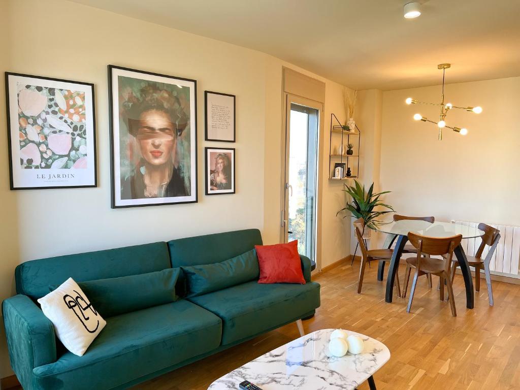ein Wohnzimmer mit einer grünen Couch und einem Tisch in der Unterkunft Apartamento de diseño con Gym y Piscina in Castellón de la Plana
