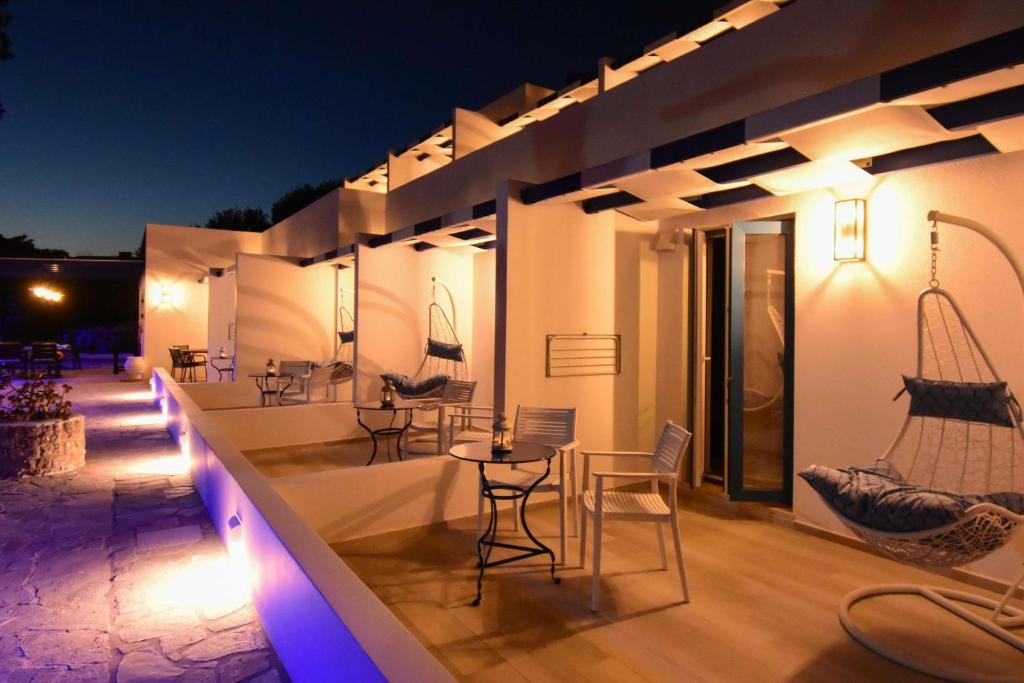 an outdoor patio with chairs and tables at night at Aphrodite Studios Kalymnos in Myrties