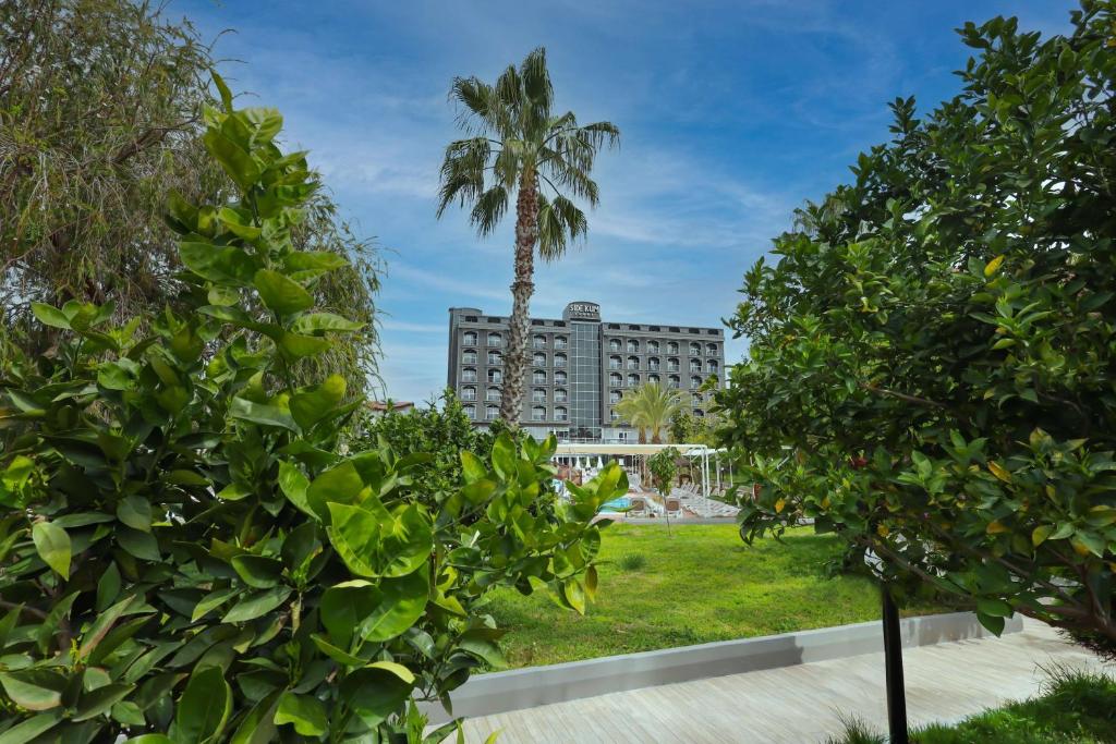 um hotel com uma palmeira e um edifício em Side Kum Hotel em Side