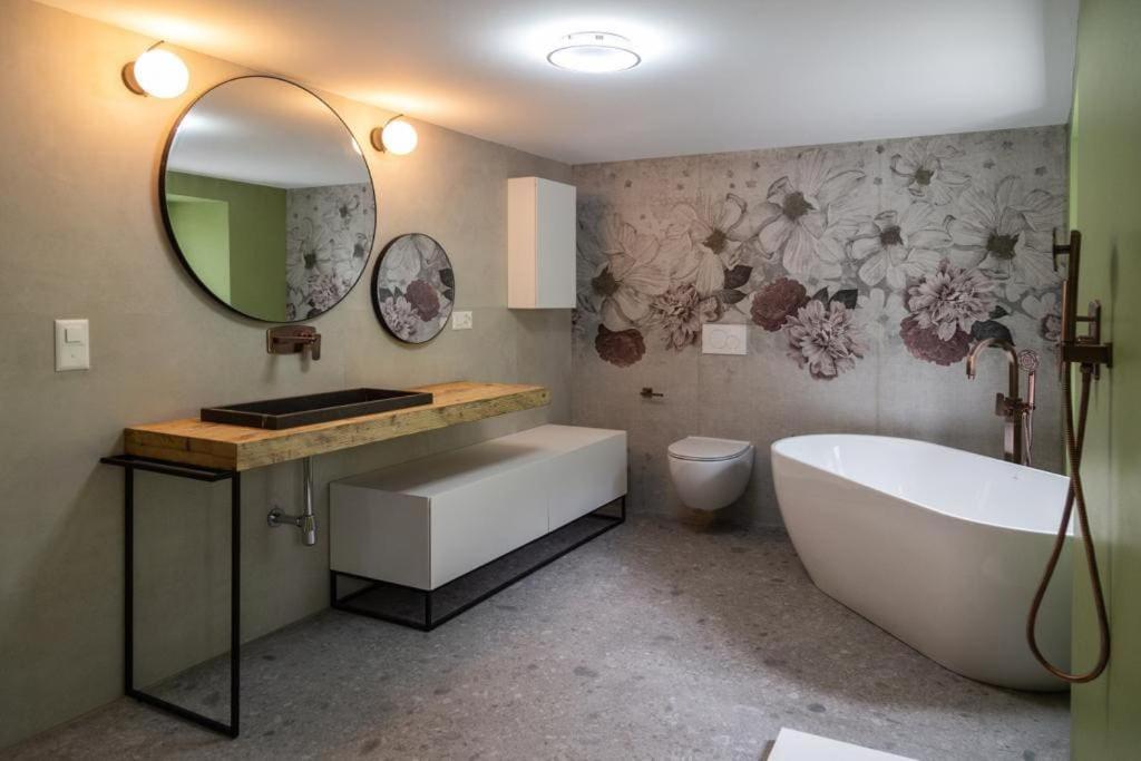 a bathroom with a tub and a sink and a mirror at Casa Dorino - Casa di vacanza ideale per famiglie in Rodi