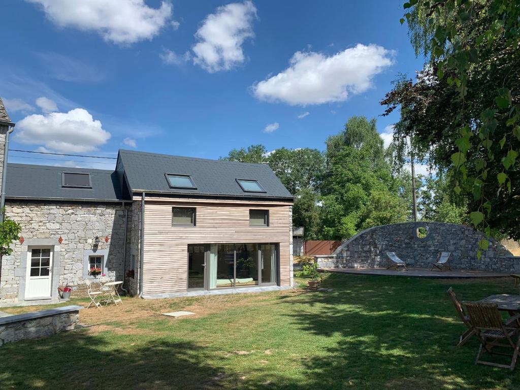 una casa con techo de pizarra y patio en L'Oeil du Condroz en Clavier