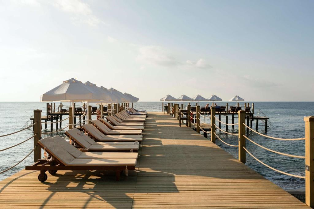 a pier with lounge chairs and umbrellas on the ocean at Seven Seas Hotel Life - Ultra All Inclusive & Kids Concept in Kemer