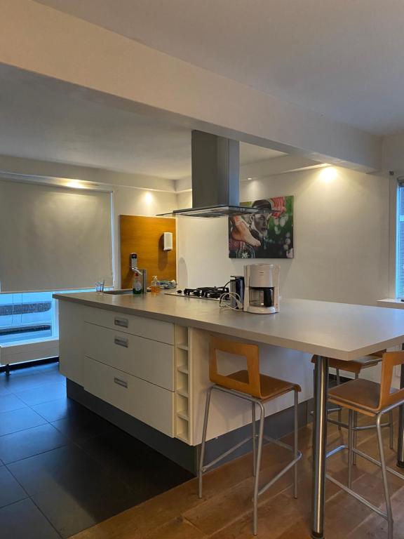 a kitchen with a counter and a table and chairs at Lovely family house nearby Amsterdam and Schiphol in Almere