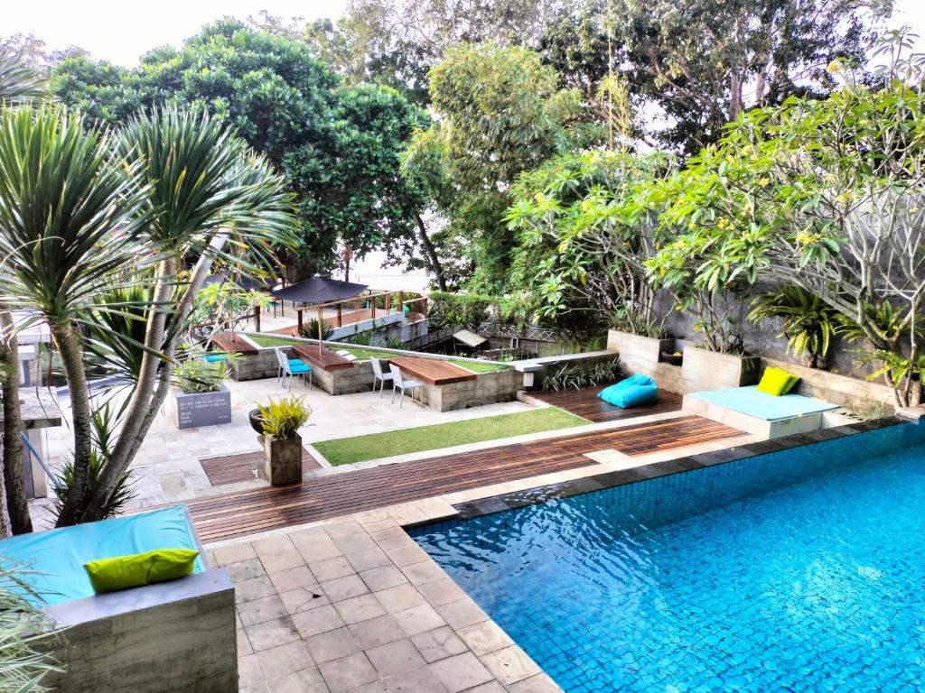 Batukaras的住宿－JavaCove Beach Hotel，一座树木繁茂的庭院内的游泳池