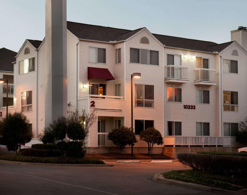 a large white apartment building with a street at Sonesta ES Suites Dallas Central Expressway in Dallas