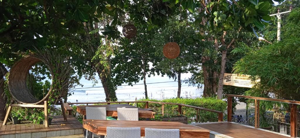 a wooden table and chairs with a view of the ocean at JavaCove Beach Hotel in Batukaras