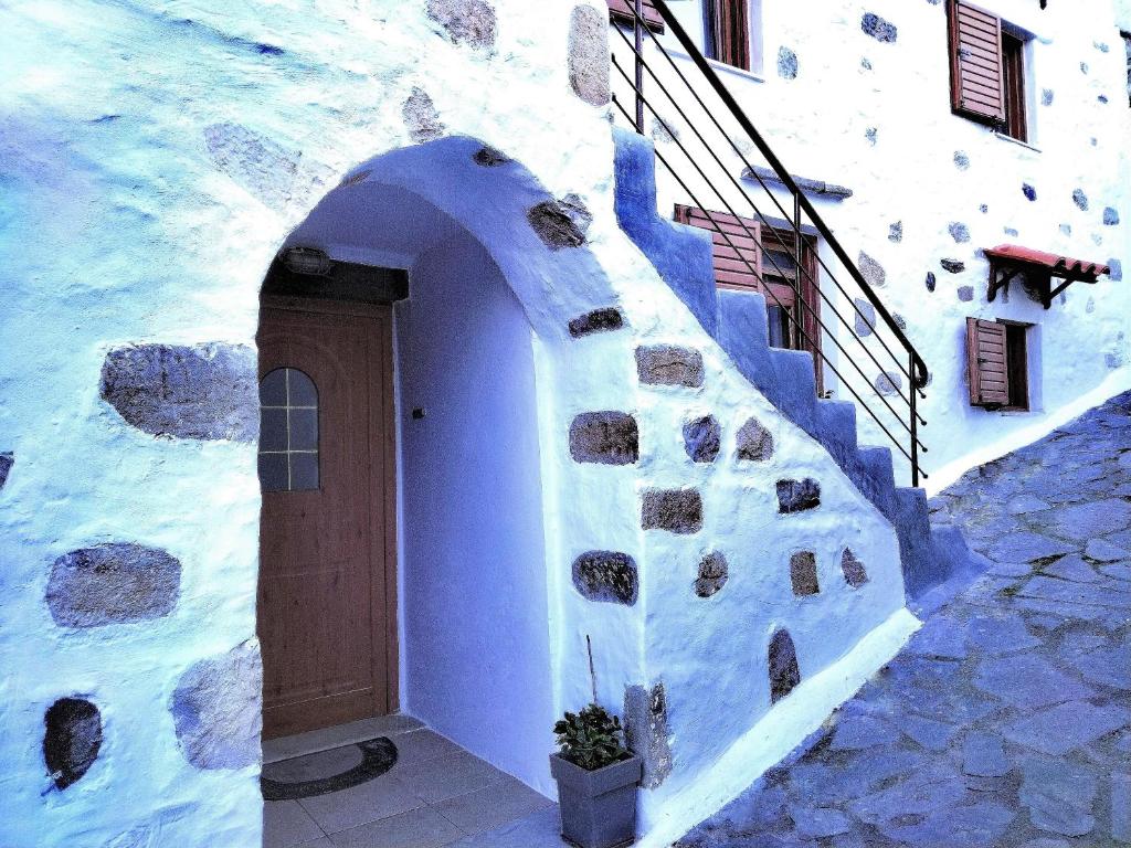 a blue and white building with a door and stairs at Afroditi Traditional Villa in Yiannioú