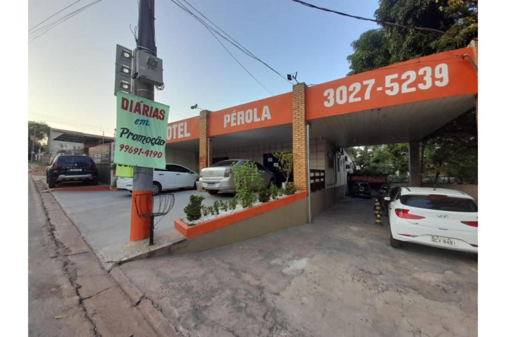 a gas station with a car parked in front of it at OYO Hotel Perola in Cuiabá