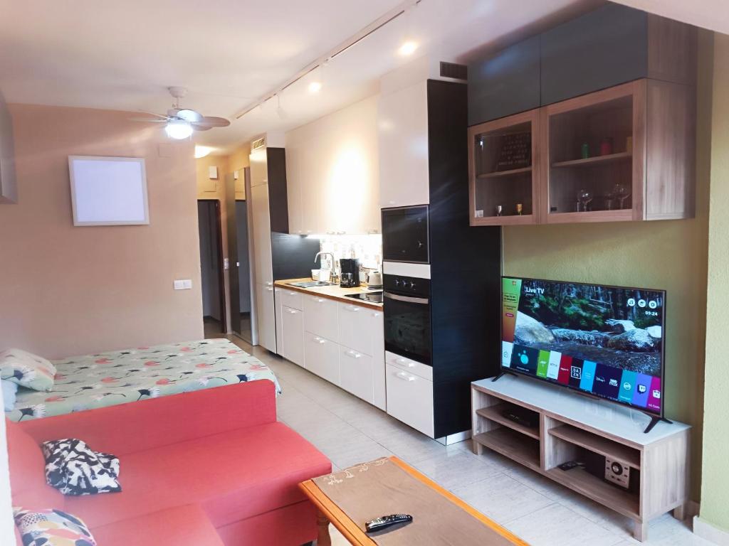ein Wohnzimmer mit einem roten Sofa und einer Küche in der Unterkunft LIM5 - Wifi, Smart TV, Centro a 5 minutos, Playa in Torremolinos