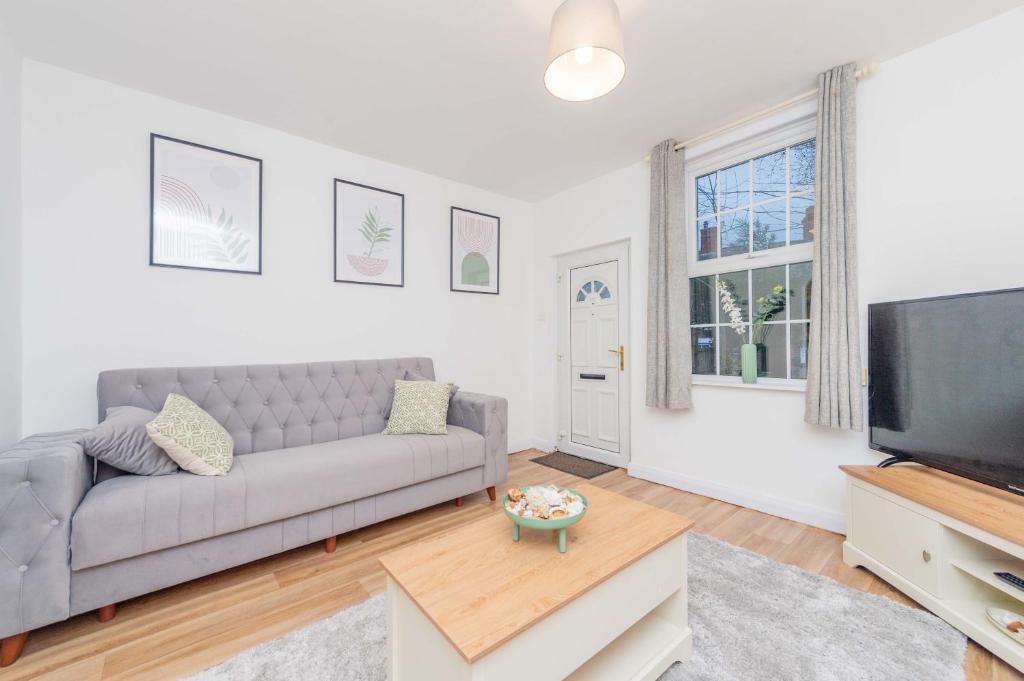 a living room with a couch and a flat screen tv at Hereford Road Shrewsbury Cottage in Shrewsbury