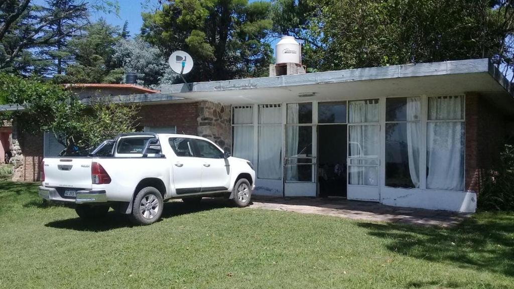 un camión blanco estacionado frente a una casa en La casita de Calamuchita en Los Reartes