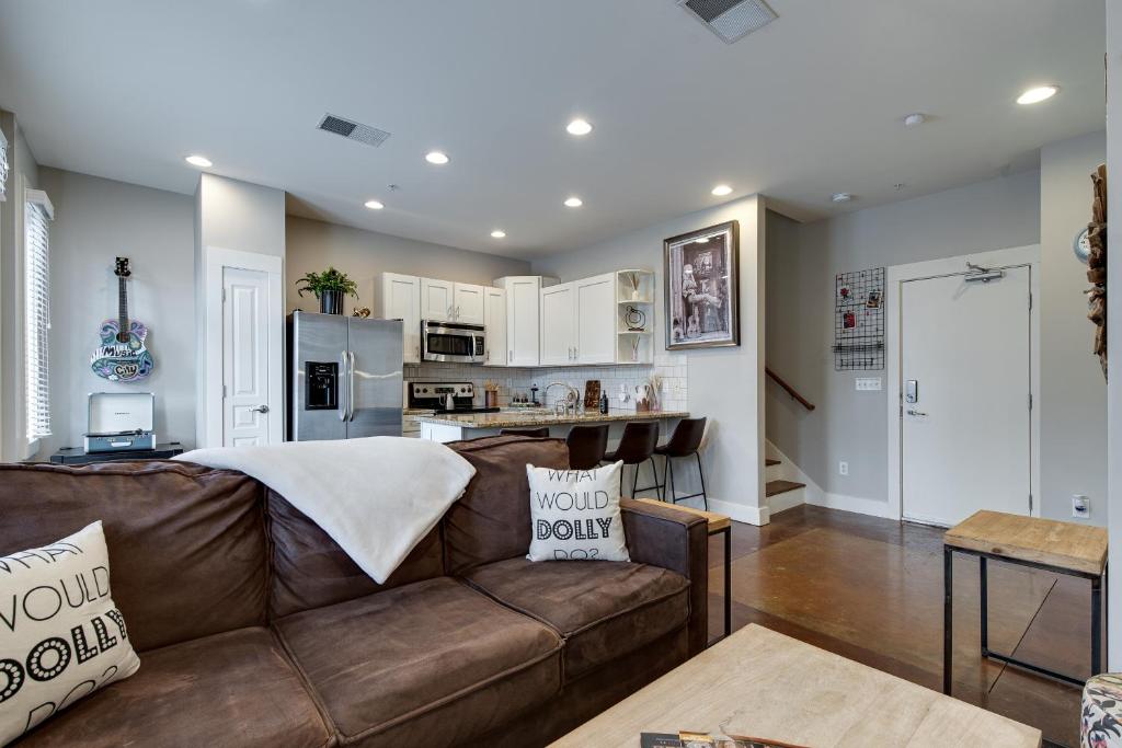 a living room and kitchen with a brown couch at Stunning Nashville Condo Minutes from Broadway in Nashville