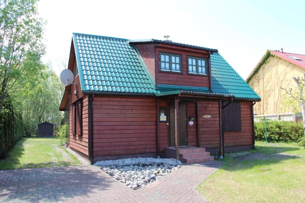 una piccola casa in legno con tetto verde di Sielski domek Grzybowo a Grzybowo