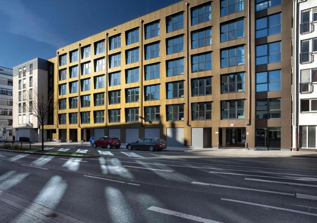 een groot gebouw met auto's geparkeerd voor het bij Green Stay in Essen