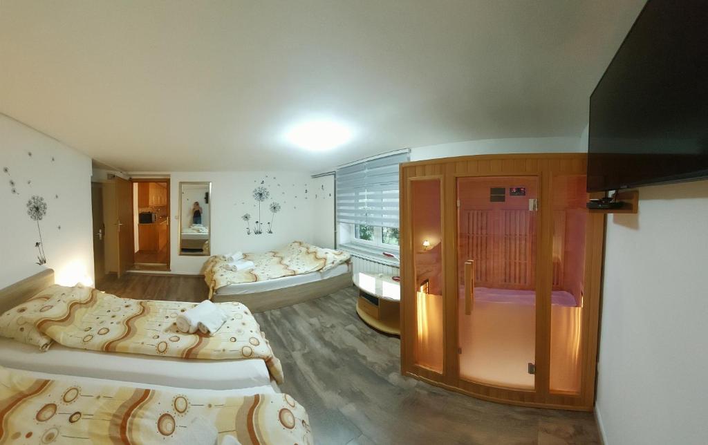 een kamer met drie bedden en een kamer met twee bij Apartma na Ravnicah in Cerkno