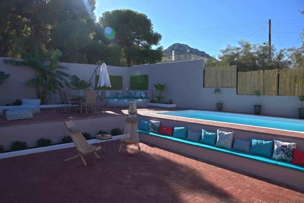 una piscina con 2 sillas y una mesa en Arsinoe Luxury Villa en Salamina