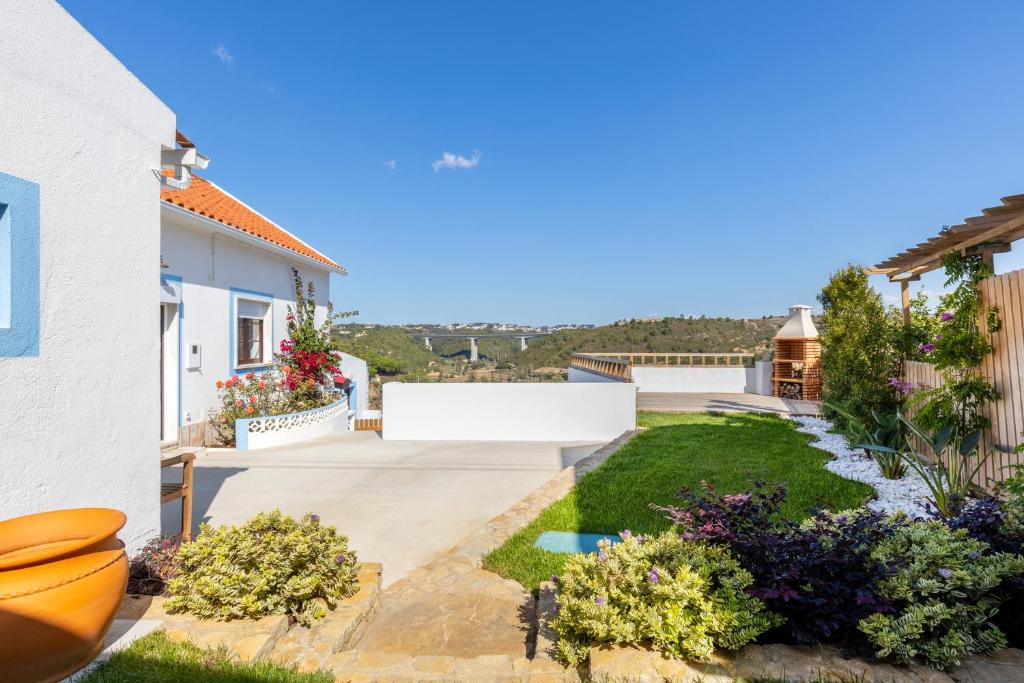 Carvoeira的住宿－Carvoeira Surf & Family Villa，享有带庭院的房屋景致