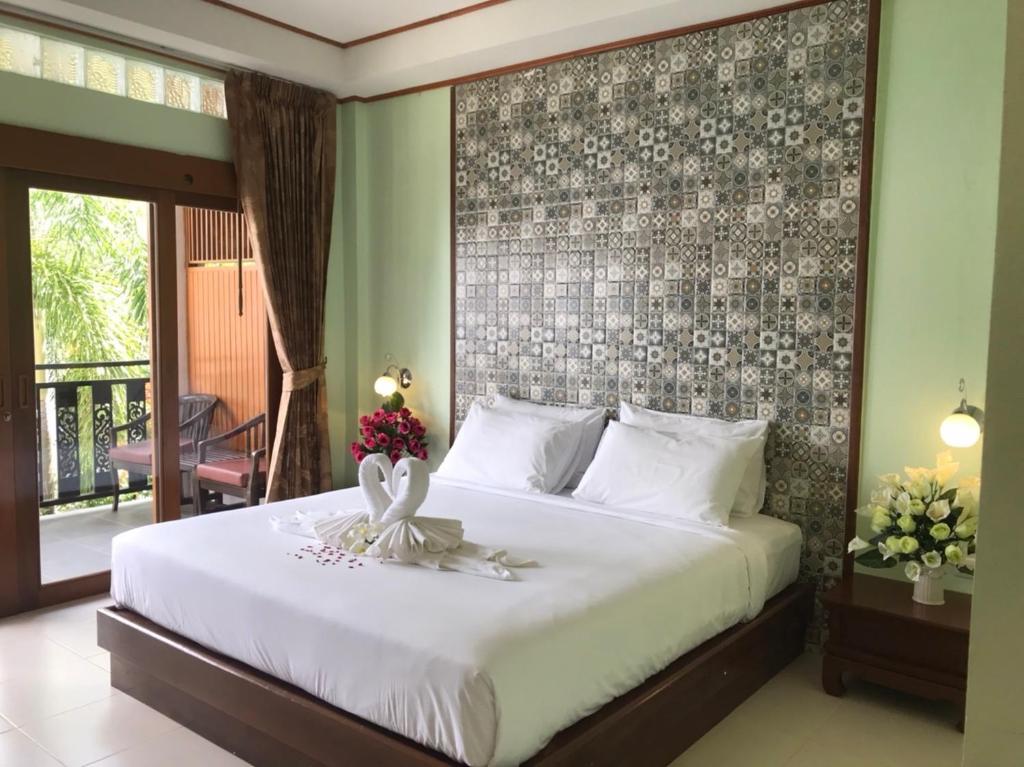 una camera da letto con un grande letto con un grande muro di Pratum Resort a Khao Lak