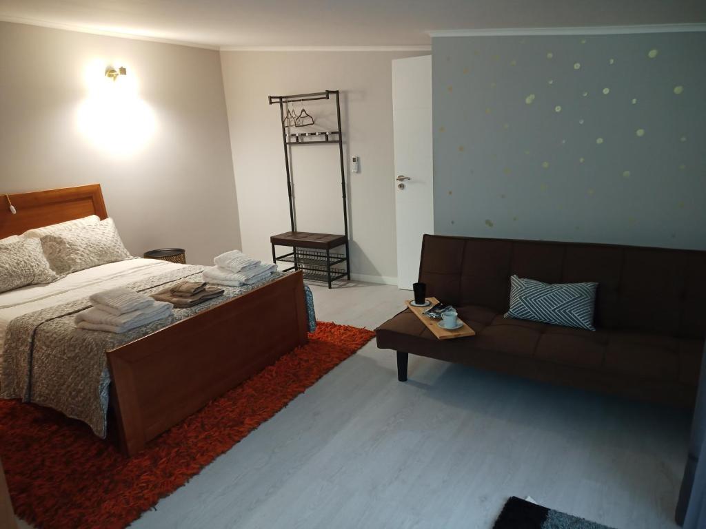 - une chambre avec un lit et un canapé dans l'établissement Casa Tí Carminda, à Mogadouro