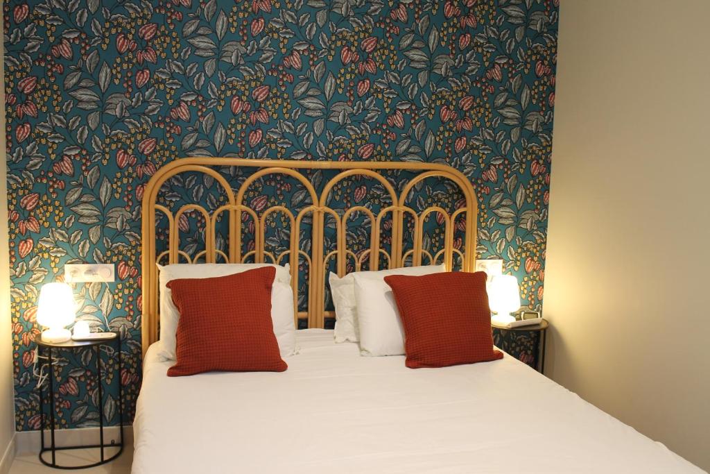 een slaapkamer met een bed met bloemenbehang bij Le gite des 3 mousquetaires in Amboise