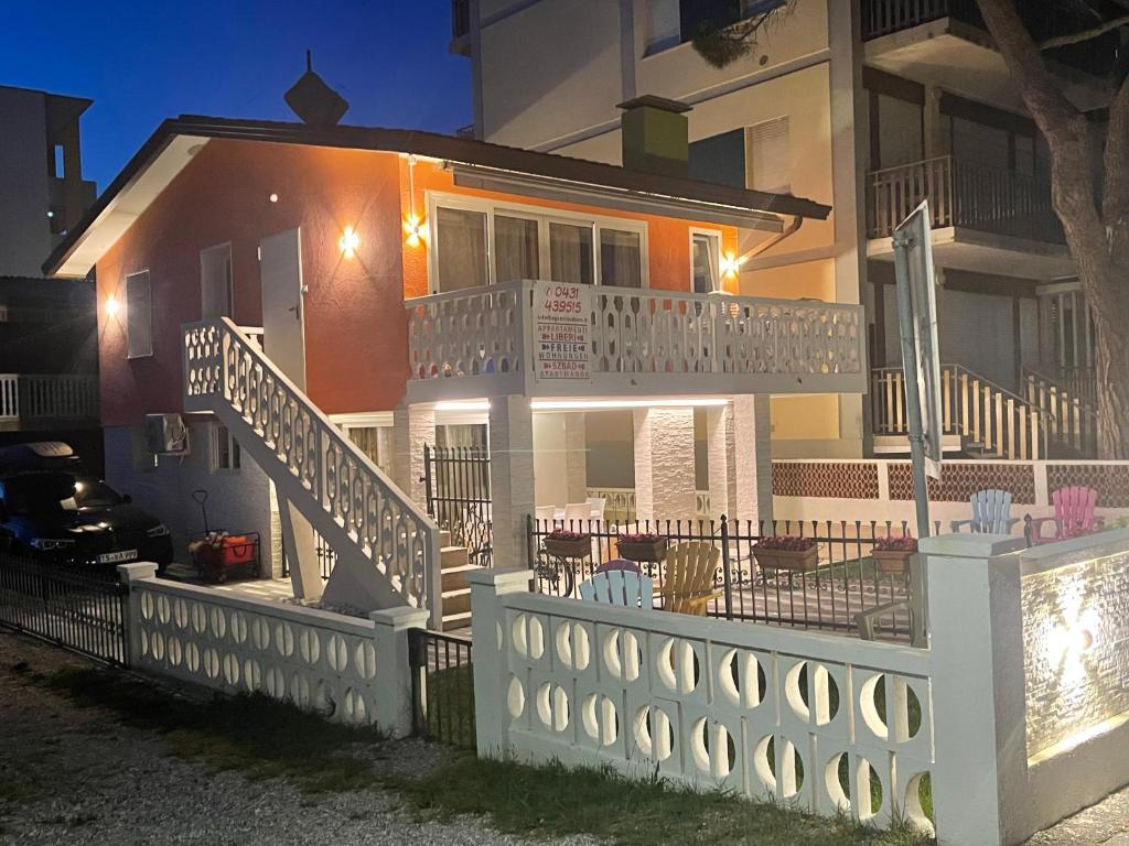 uma casa com uma varanda com mesas e cadeiras em Luna em Bibione