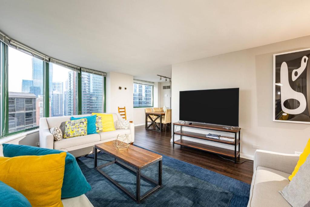 ein Wohnzimmer mit einem Sofa und einem Flachbild-TV in der Unterkunft 3b/3b SkyLoft with Navy Pier View Gym & Pool by ENVITAE in Chicago