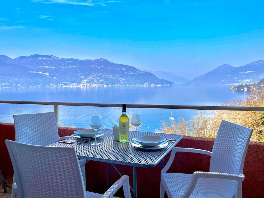 a table and chairs on a balcony with a view of the water at Ferienwohnung Casa Belvedere in Brezzo