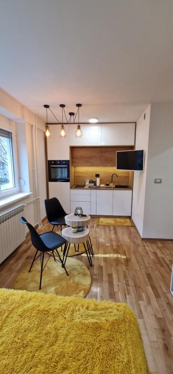 un salon avec une table et des chaises et une cuisine dans l'établissement Apartment GOLD STAR, à Sarajevo